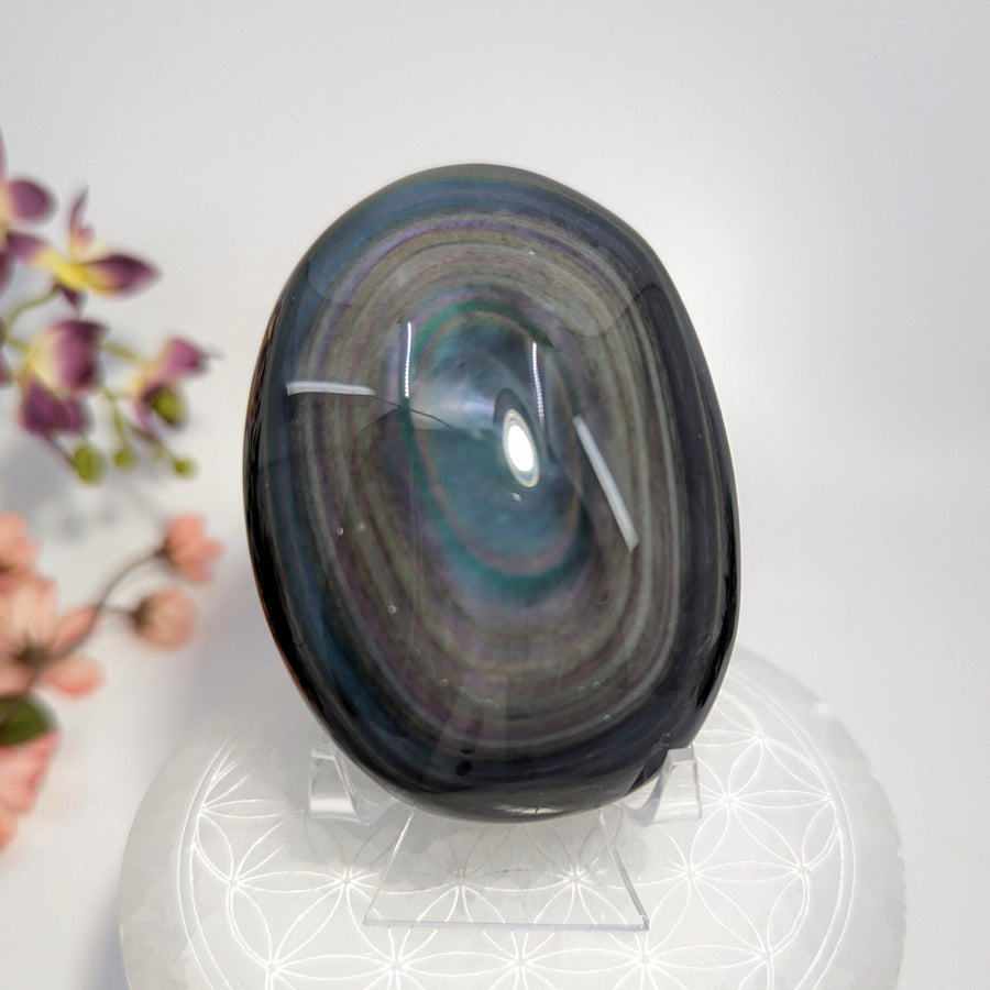 Polished Rainbow Obsidian palm stone with iridescent bands from volcanic molten lava cooling