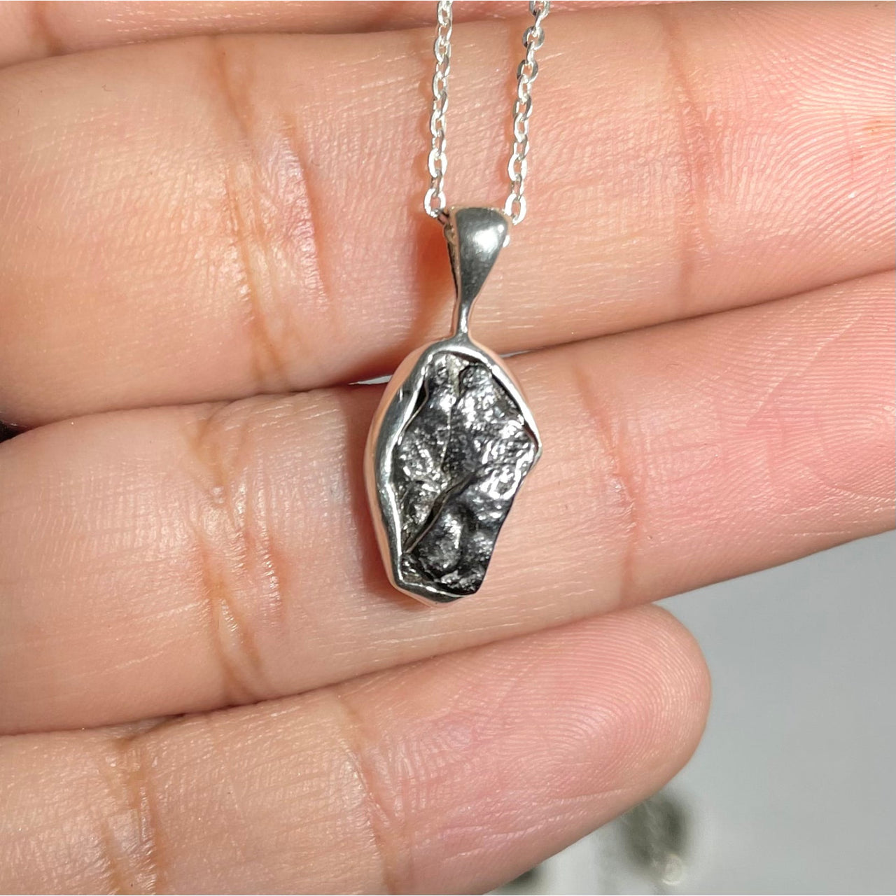 Person holding Raw Sterling Silver Crystal Pendant for positive energy