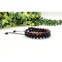Two beaded bracelets featuring Red Tiger Eye and Black Lava woven adjustable beads