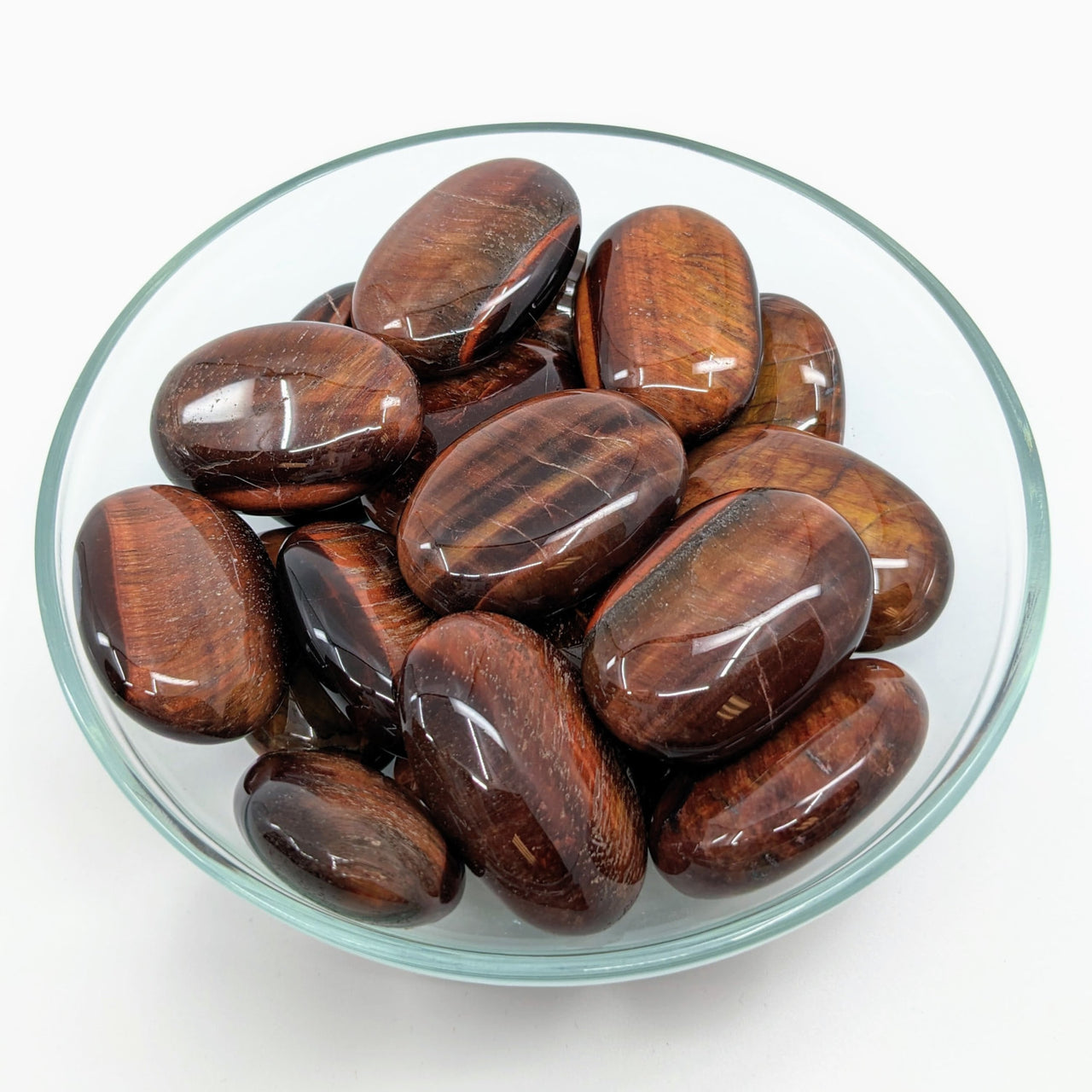 A bowl of dates beside a Red Tiger’s Eye Palm Stone #LV2723, ideal for healing energy