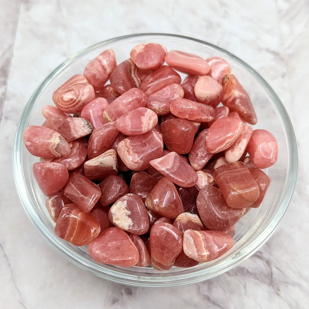 A bowl of raw chicken meat next to Rhodochrosite Tumble Mini Stones #LV2284