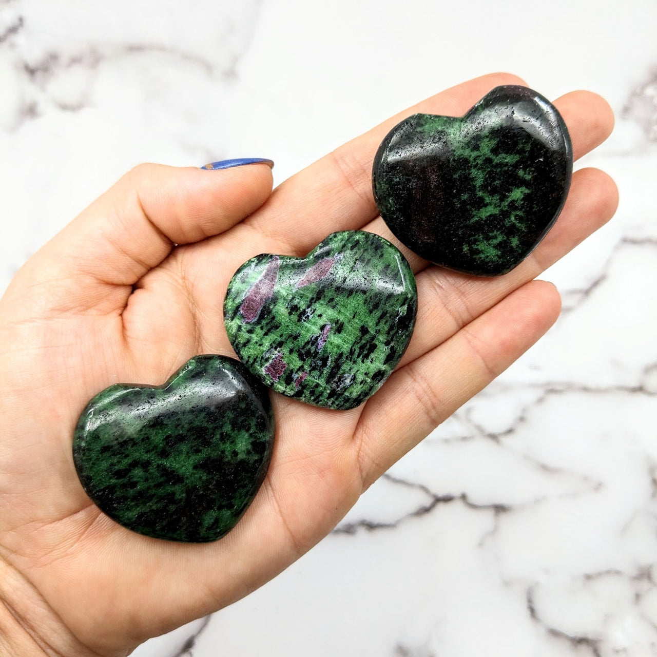 Ruby Zoisite 1.7’ Polished Heart #LV1817: Two green and black marble hearts on a hand