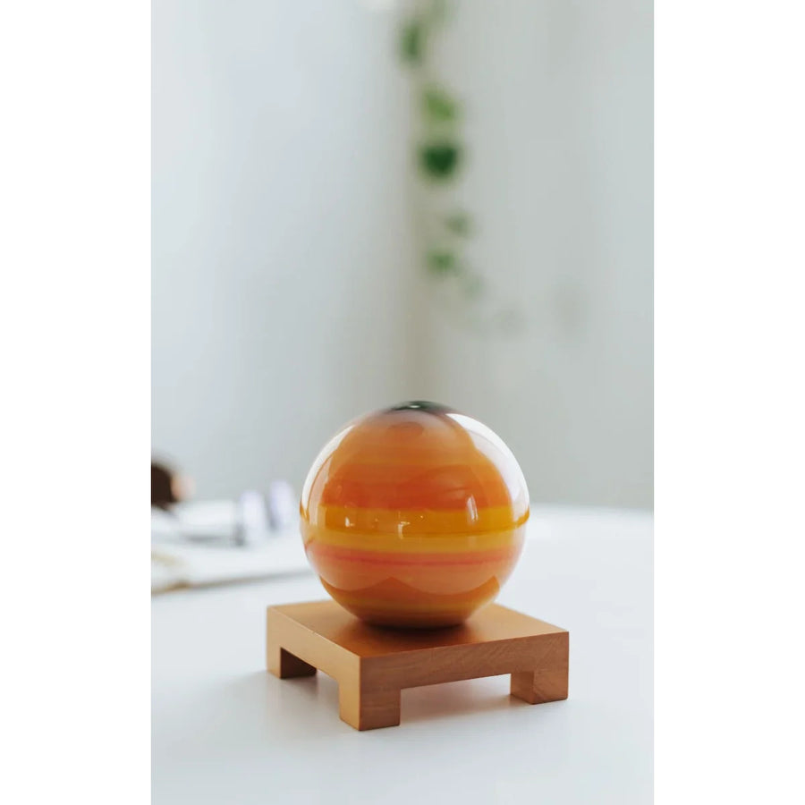 Orange striped glass sphere Mova Globe with earth relief map rotating display