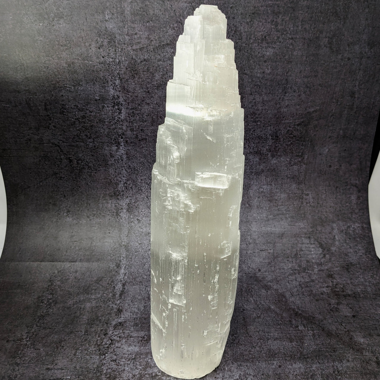 Close-up of a Selenite 15’ Tower Lamp (#SK9984) crystal on a black background