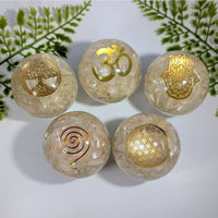 Five translucent light-colored selenite orgonite spheres with gold embossed spiritual symbols for crystals and gemstones