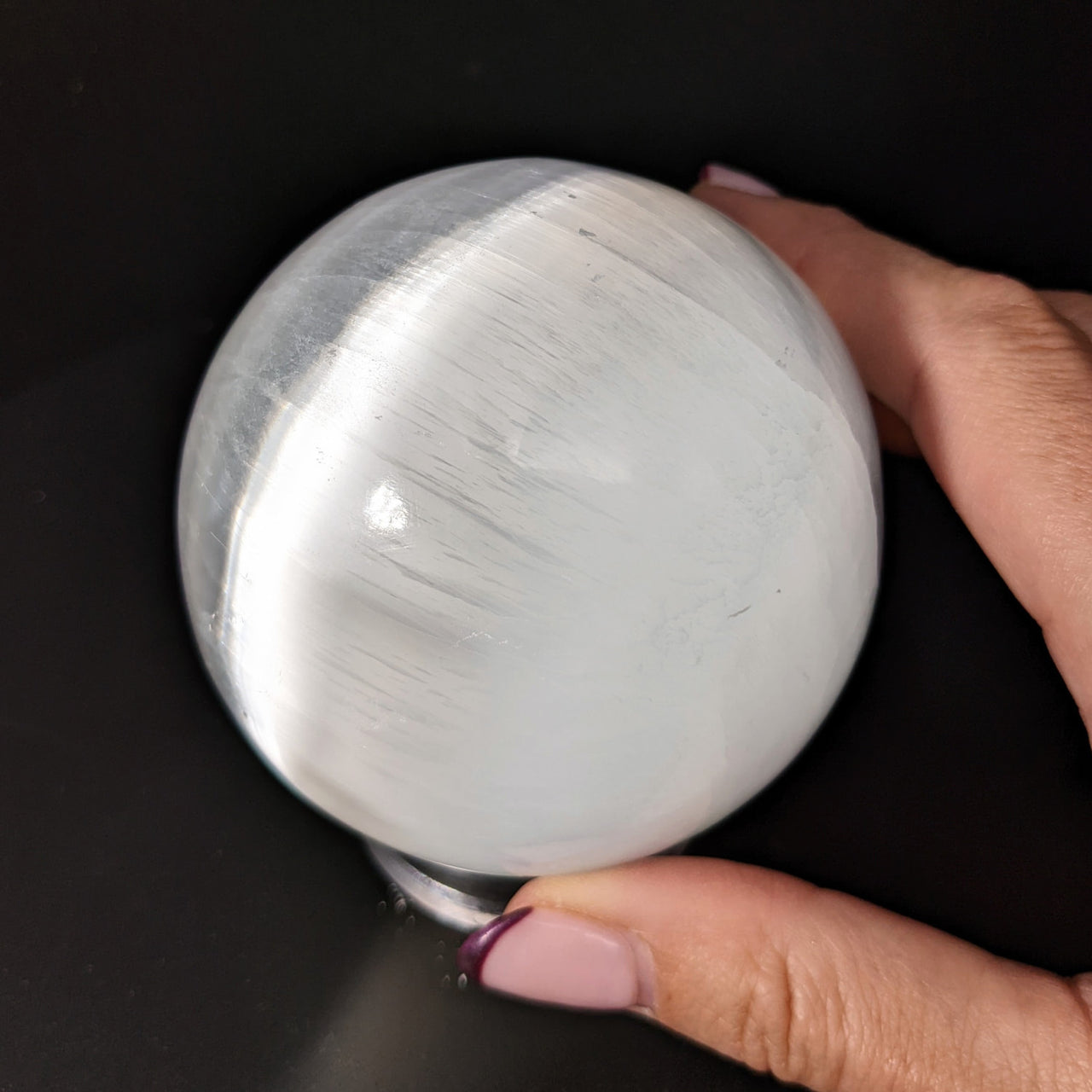 Person holding a Selenite 3’ Sphere, approximately 541g (SKU: SK9327)