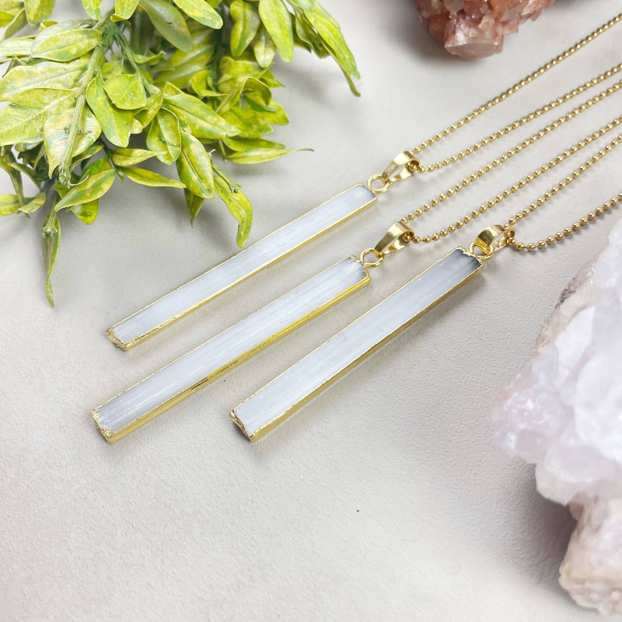 Three elegant white selenite geode pendants with gold edges on 18’’ chains