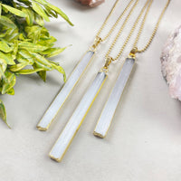 Three elegant white selenite bar pendants in gold frames on 18’’ chains