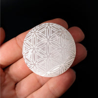 Thumbnail for A person holding a Selenite Etched 1.5’ Flower of Life Palm Stone #LV4132 in their hand