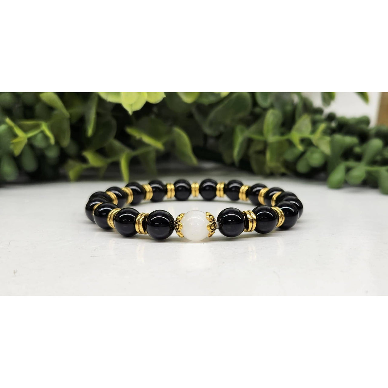 Black onyx and gold beaded bracelet with white moonstone accent, 8mm, 7.5 inches