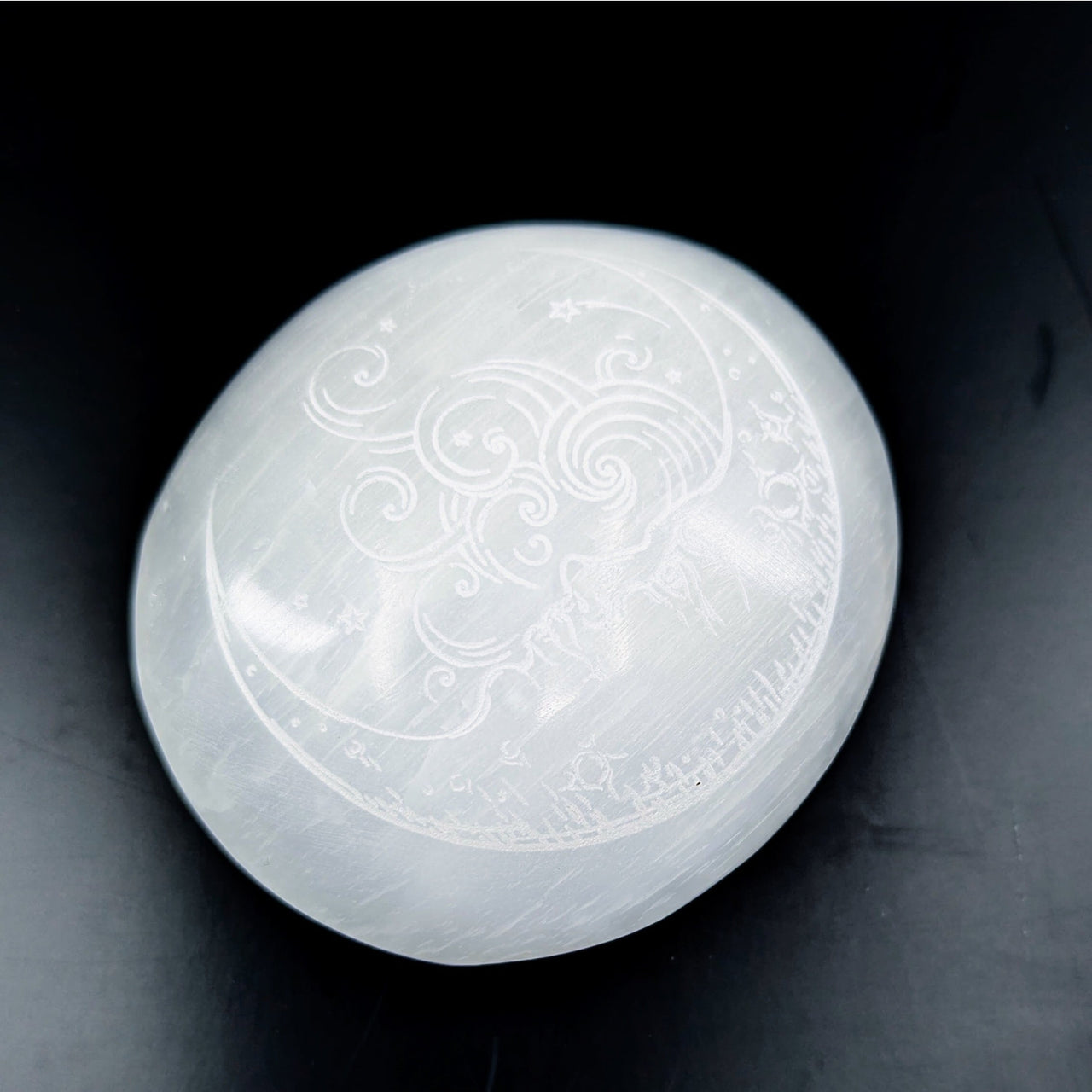 Smooth translucent white Selenite palm stone with carved celestial and crescent moon designs