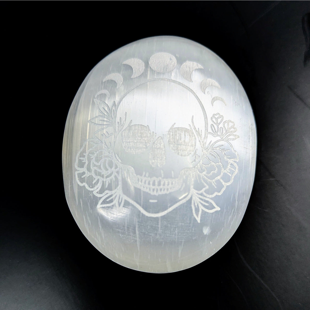 Engraved White Selenite Palm Stone with Skull Floral Accents and Moon Phases