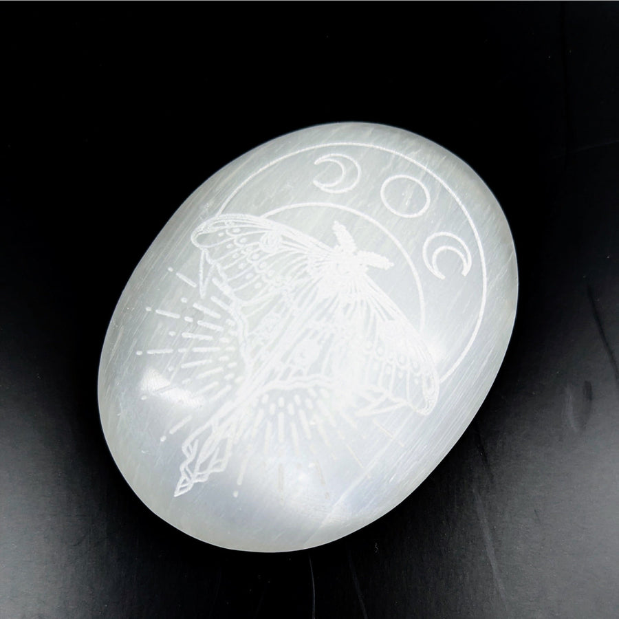 Luminous white Selenite palm stone engraved with moth and moon phases, 3-inch size