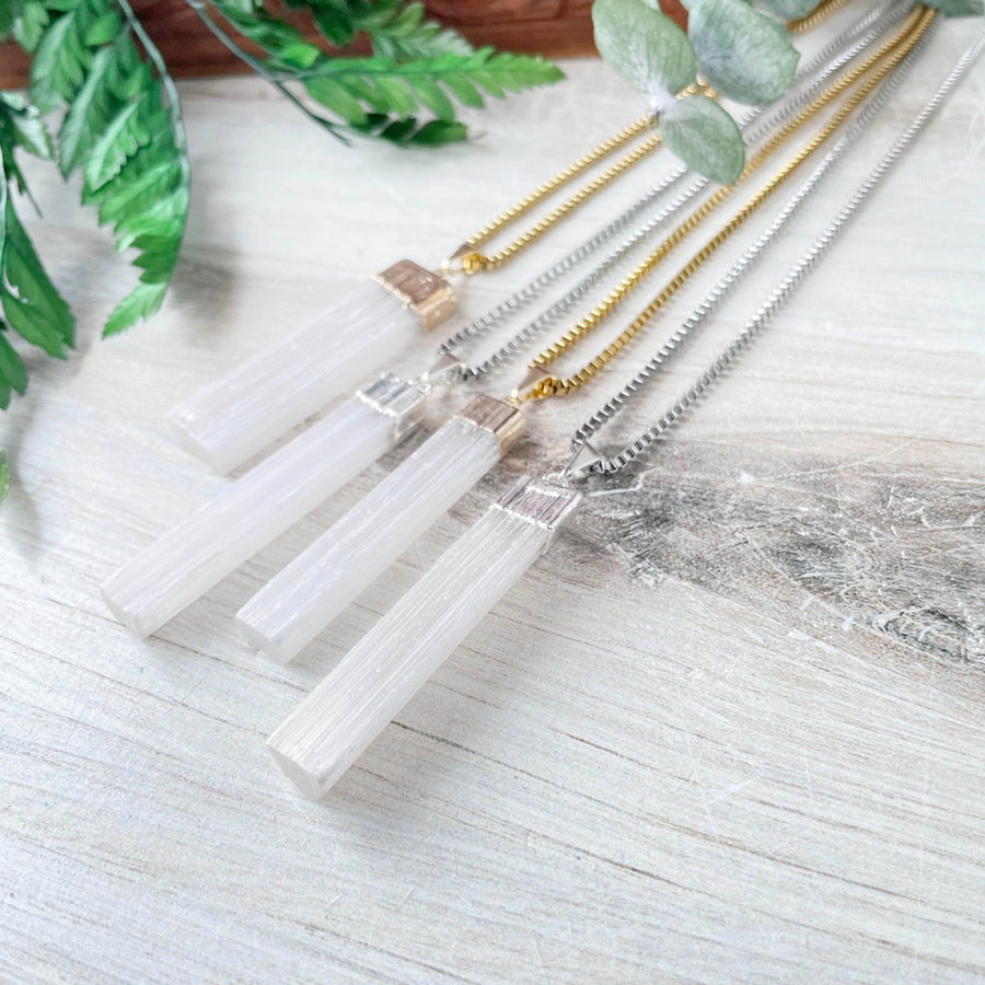 Three elegant white selenite pendant necklaces with metallic caps on gold or silver chains, LV9192