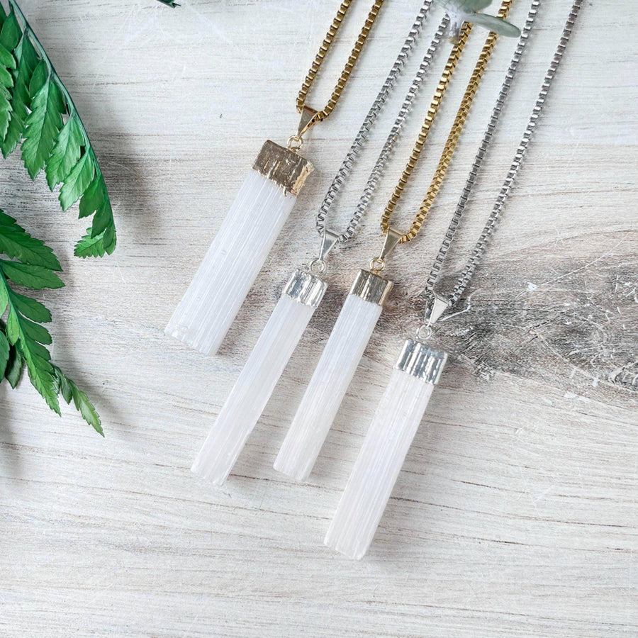 Three white selenite crystal pendants with gold and silver caps on box chains, LV9192