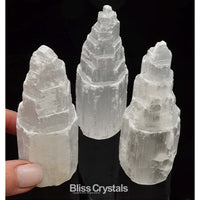 Thumbnail for Hand holding white quartz crystal with two more beside the SELENITE Skyscraper Tower