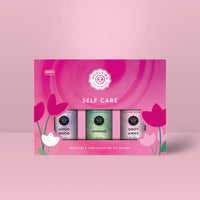 The Self Care Essential Oil Collection Set of 3 LV9978 with good mood, unwind, and drift away bottles on pink floral background