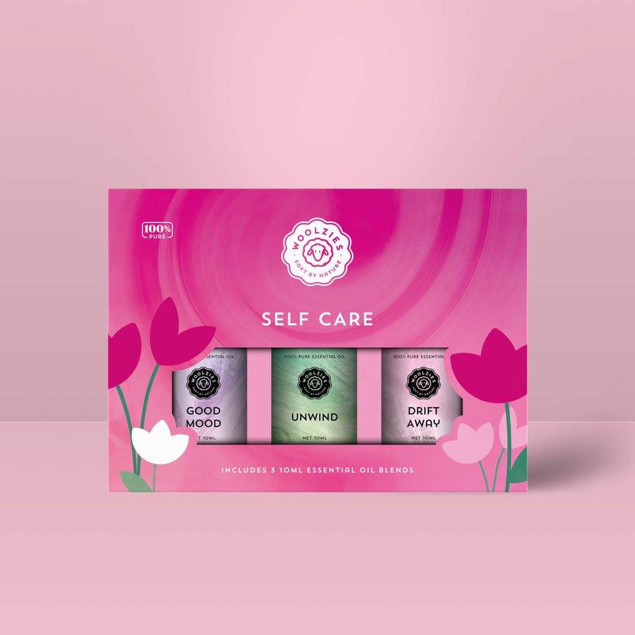 The Self Care Essential Oil Collection Set of 3 LV9978 with good mood, unwind, and drift away bottles on pink floral background