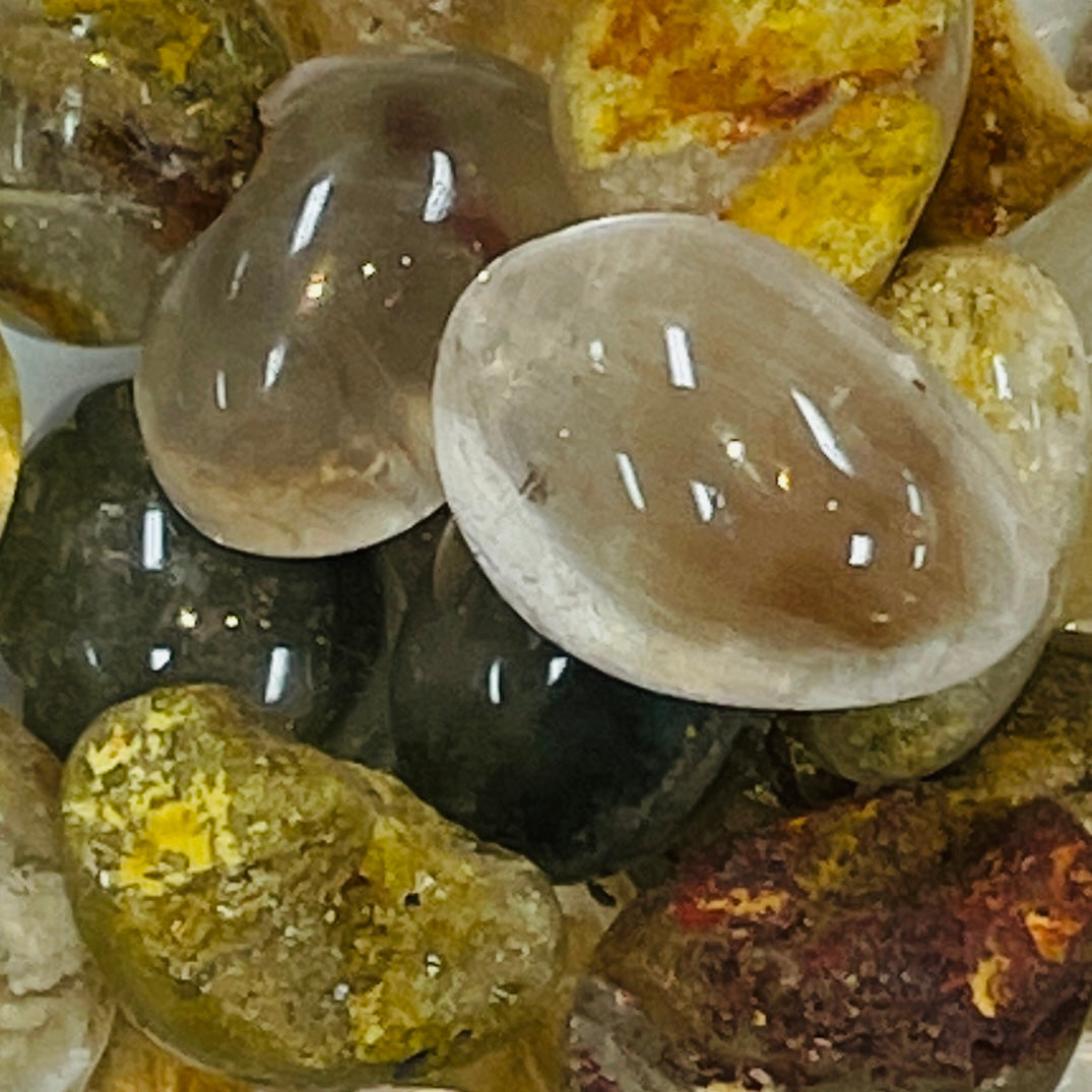 Polished Shaman Garden Quartz spheres and rough mineral specimens in yellow and red tones