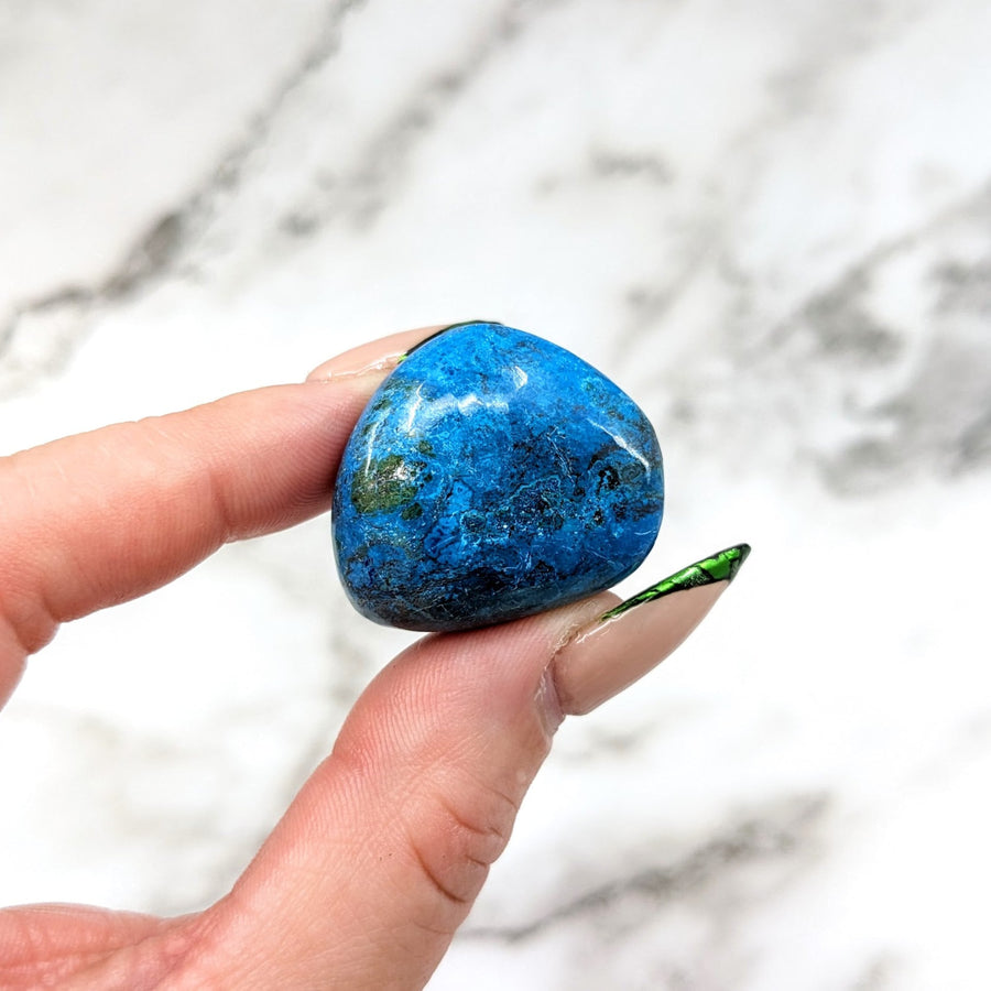 Hand holding blue marble ball, Shattuckite tumbled stone 1.1’ #LV4567