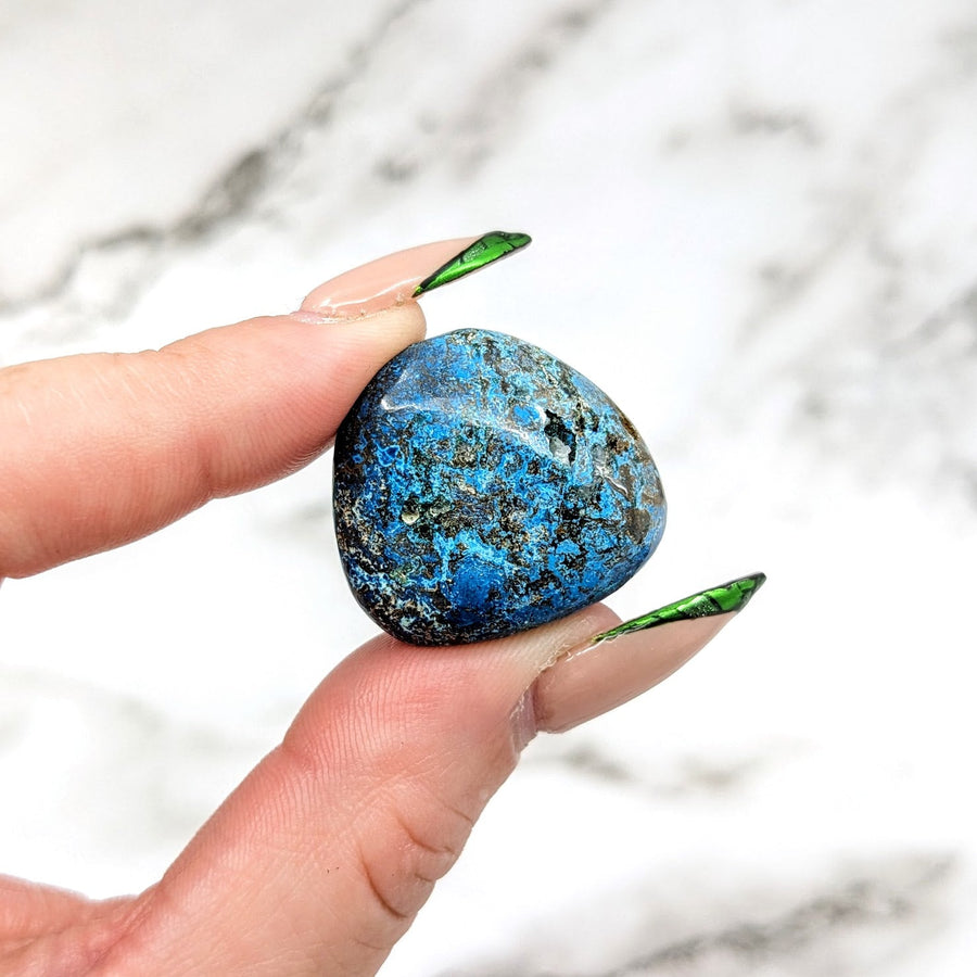 Person holding Shattuckite tumbled stone with green leaves - Product #LV4572