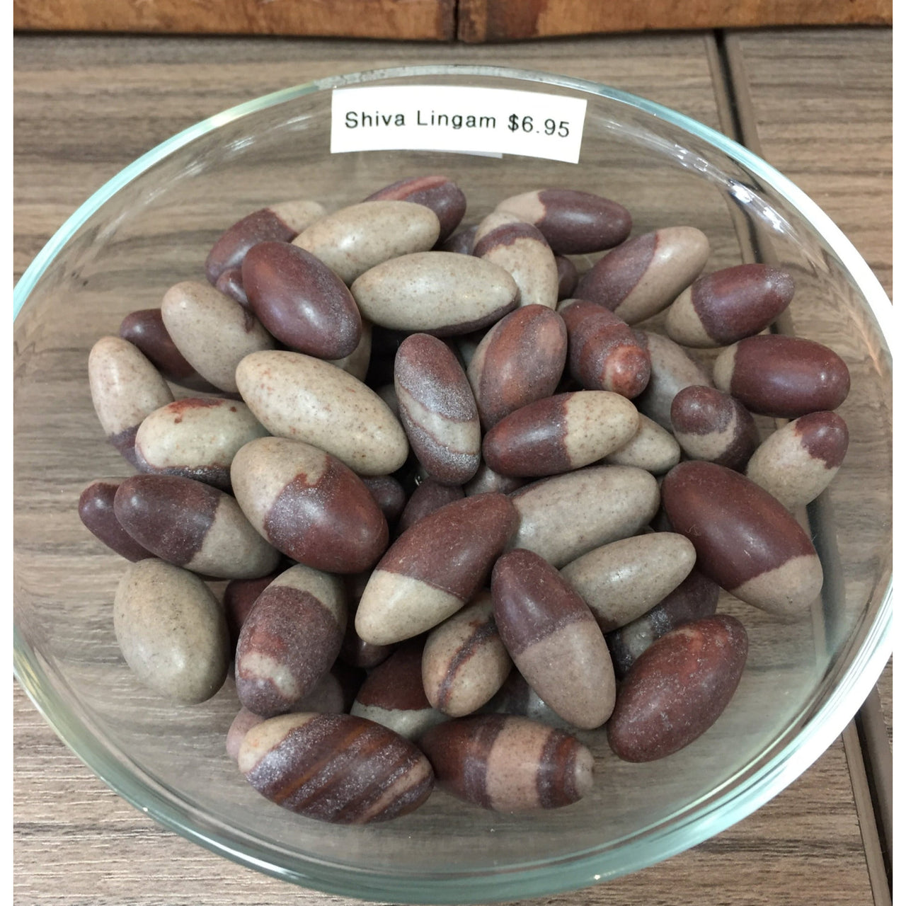 Bowl of Shiva Lingam stones in brown and beige for spiritual practices and decor