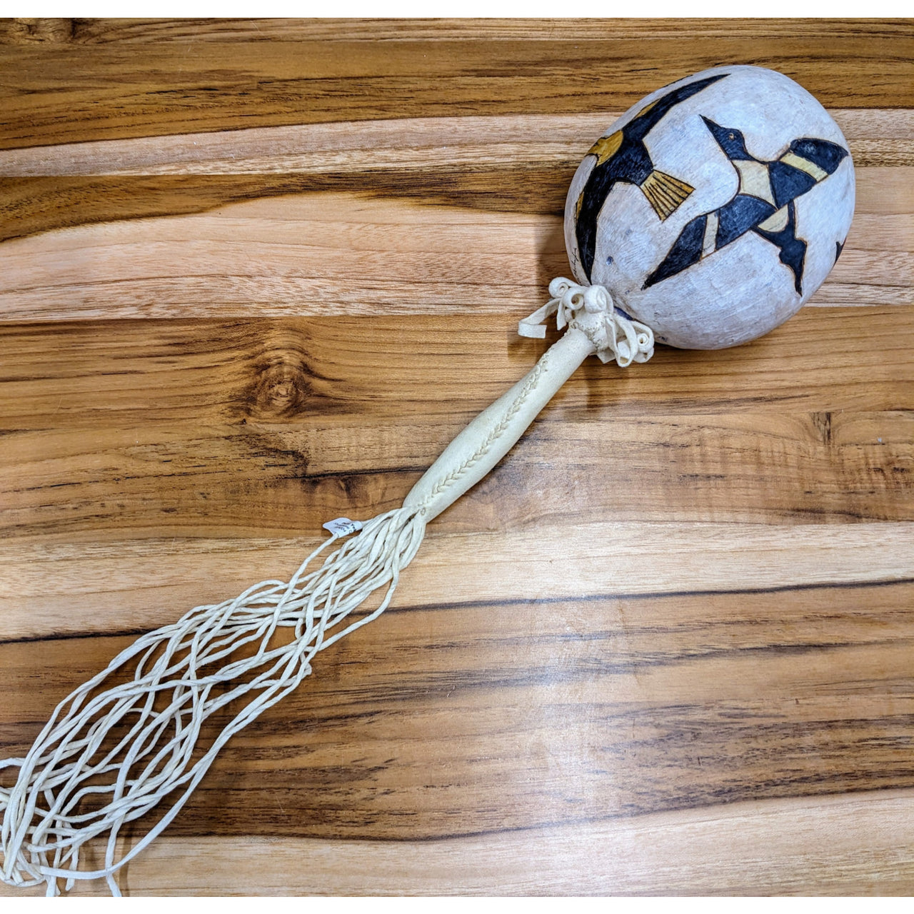 Gourd rattle by Pete Yellowjohn on wooden floor with soccer ball and string for added character