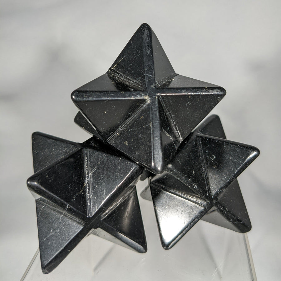 Stacked black star-shaped polyhedra in the Shungite Merkaba C084 product