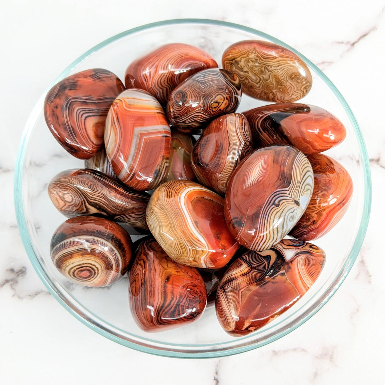 Silk Agate 1.6 - 2.2’ Pebble Stones #LV1573 in a bowl with red and brown marbles