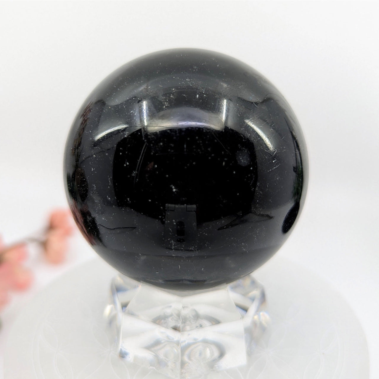 Polished black Silversheen Obsidian 2.4-inch sphere resembling volcanic molten lava cooling