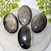 Four polished Silversheen Obsidian 2’’ palm stones #BC0877 on white plate