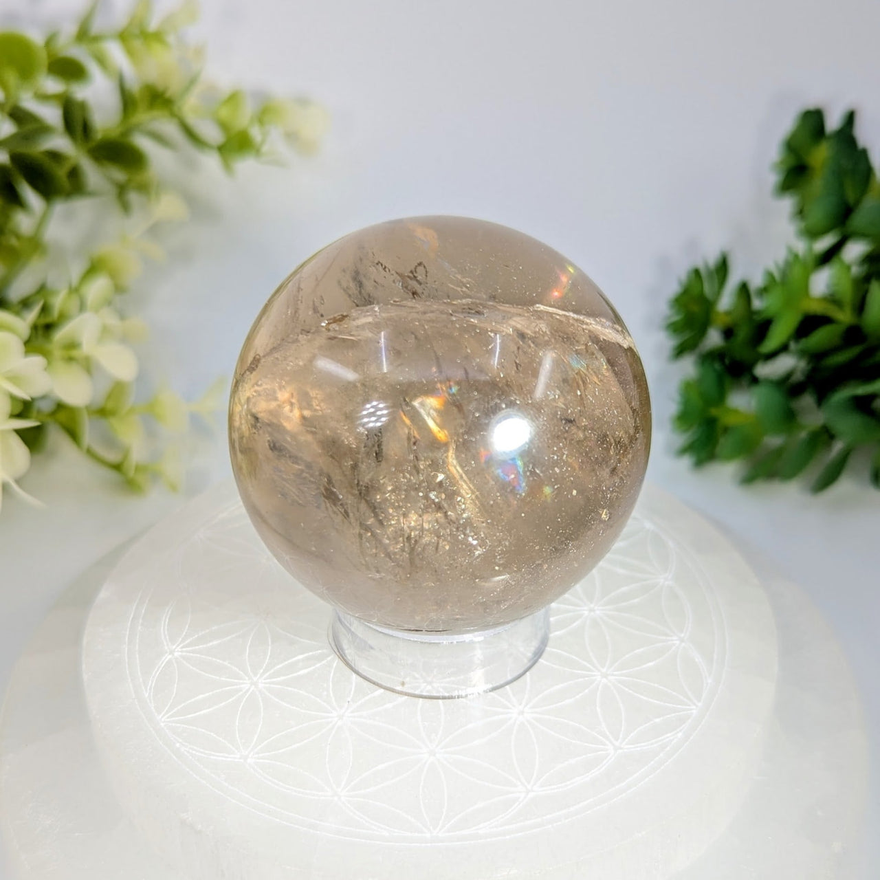 Smoky quartz 2.1 inch sphere with translucent smoky quartz and golden inclusions on a white geometric-patterned stand