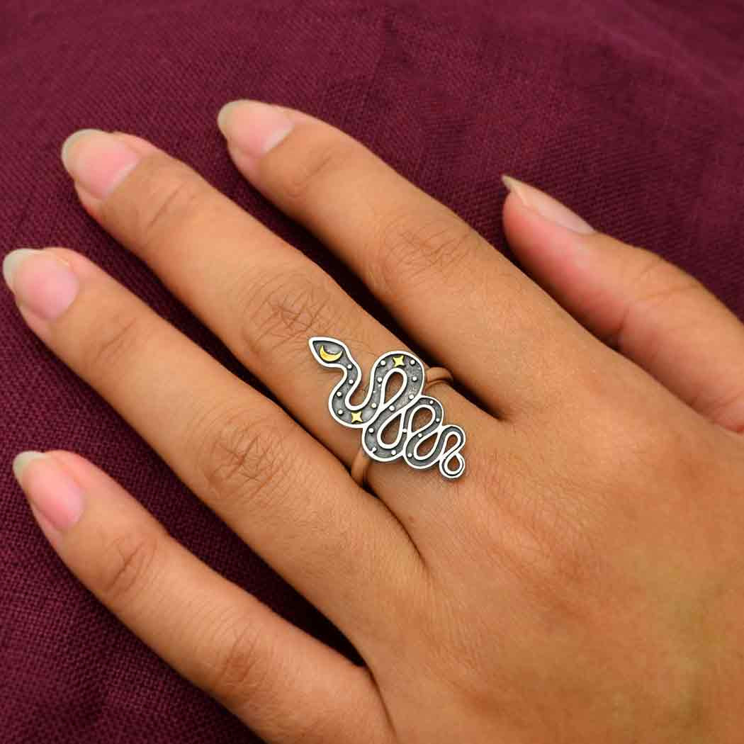 A woman’s hand wearing the Snake with Bronze Star & Moon Sterling Silver Ring #J045