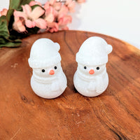 Two glittery white snow quartz snowman figurines with hats and scarves