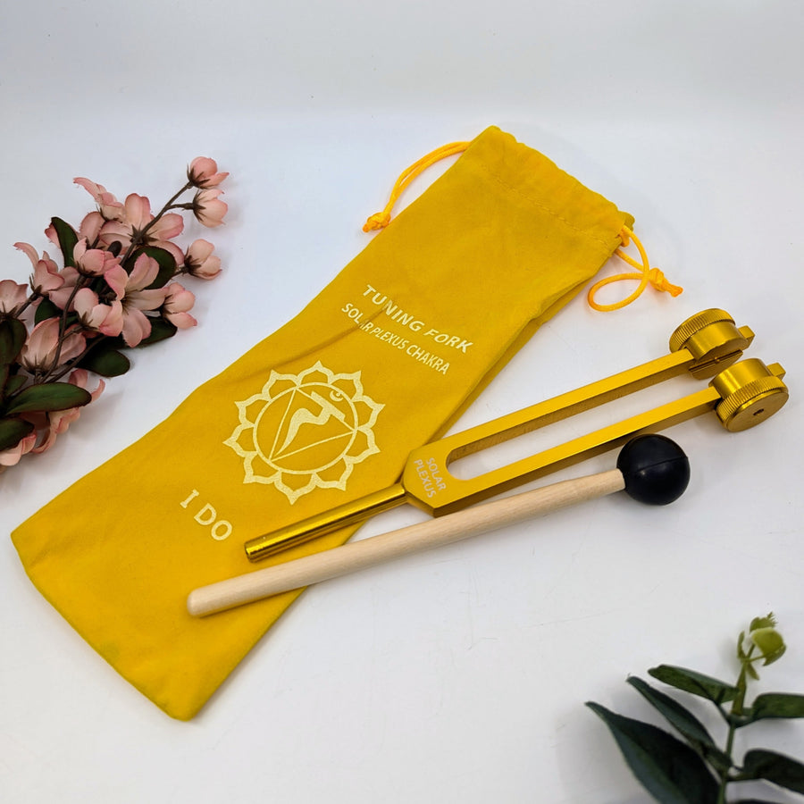 Golden tuning fork with mallet and yellow pouch for Solar Chakra healing therapy