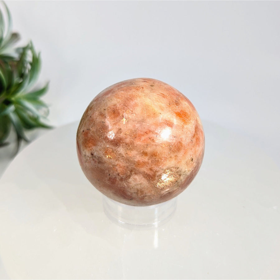Polished Sunstone 1.9-inch sphere with orange pink and gold tones for healing and decor