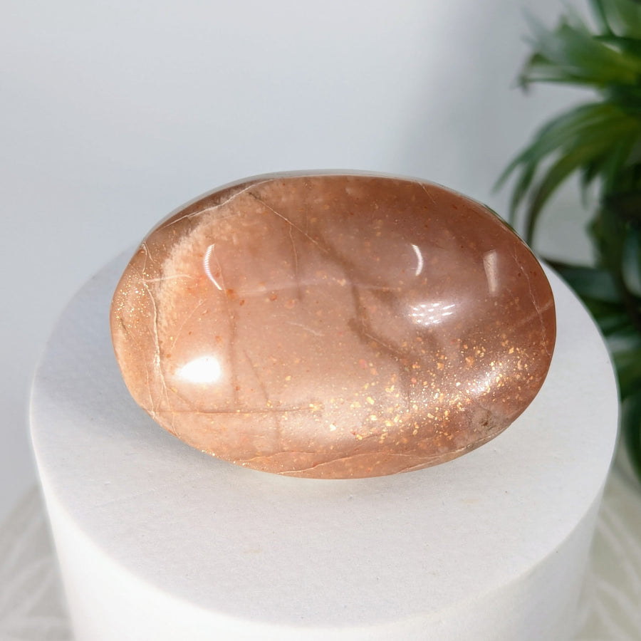 Polished peach-colored Sunstone Moonstone 2-inch palm stone for healing and meditation
