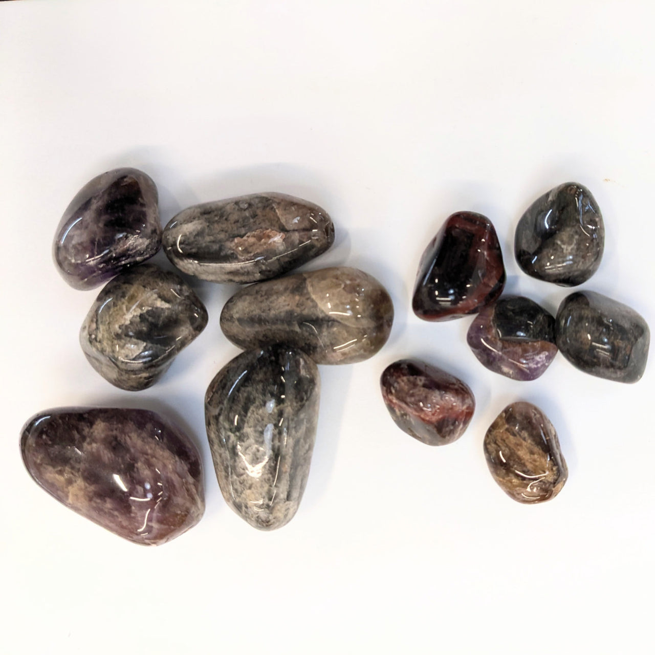 Polished Super 7 Tumbled stones featuring dark gray and reddish-brown colors