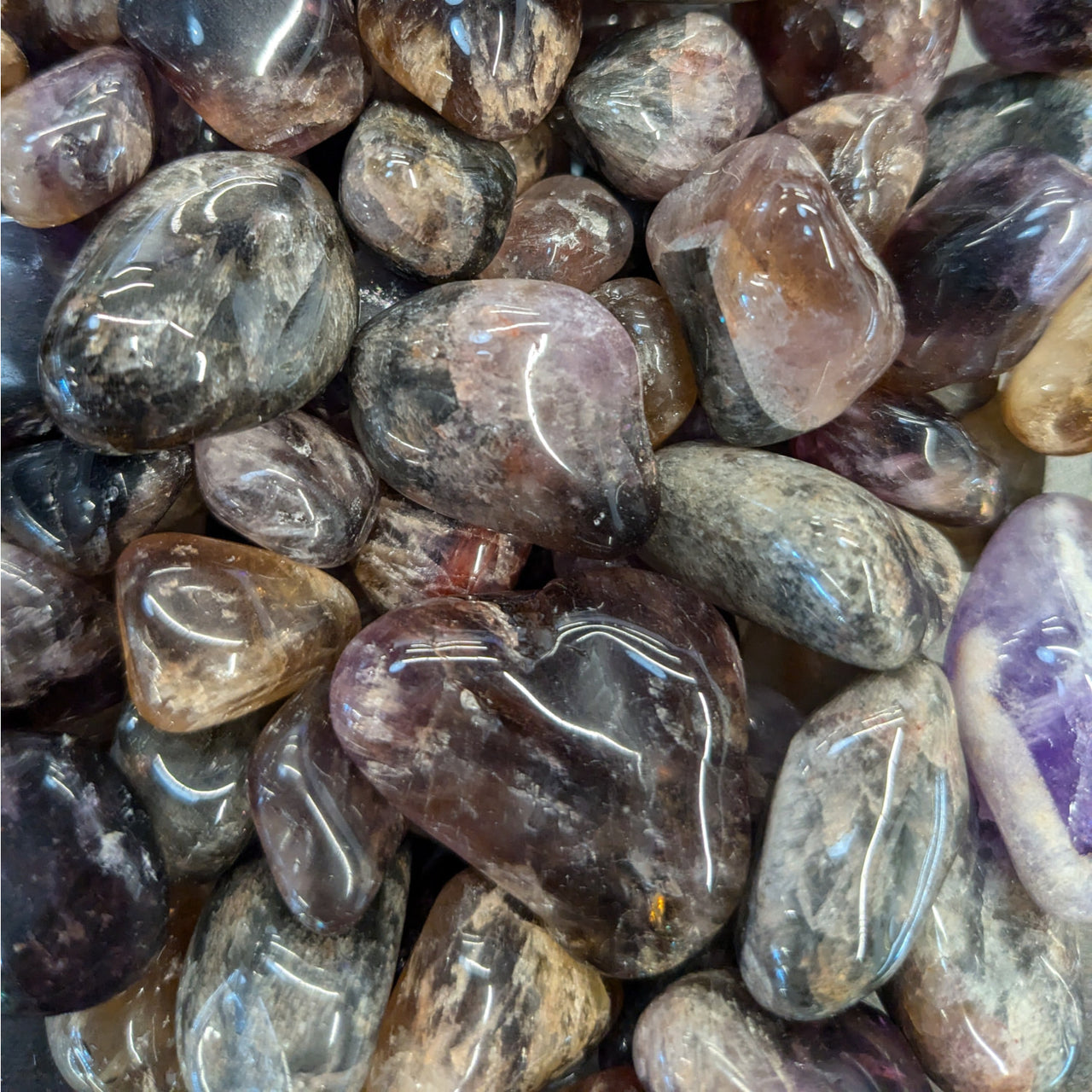 Polished Super 7 Tumbled Stones in gray, brown, and purple for item tier benefits