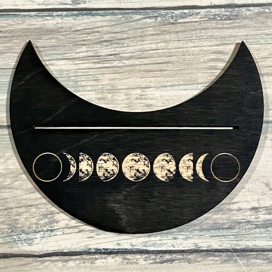 Black crescent moon phase wall art with gold rings and white phases