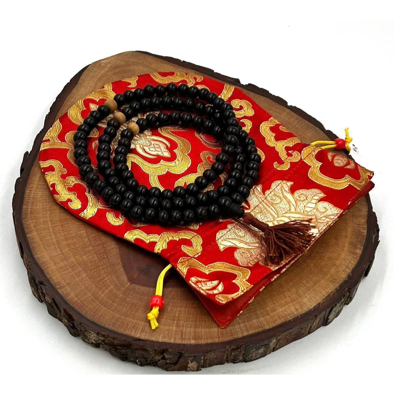 Black beaded Mala necklace on red and gold pouch for Tibetan Buddhist meditation