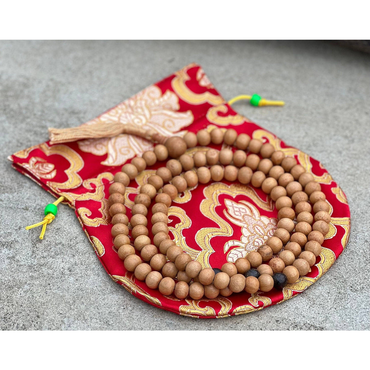 Wooden prayer beads on red and gold patterned silk pouch for Tibetan Buddhist mala