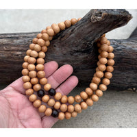 Wooden beaded mala necklace with sandal wood beads and silk pouch display