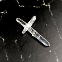 Tibetan quartz 2-inch intersect point crystal cross #BC1228 on dark surface