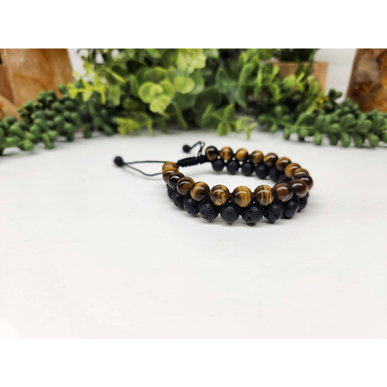Two beaded bracelets featuring Tiger’s Eye and Black Lava woven on adjustable cords