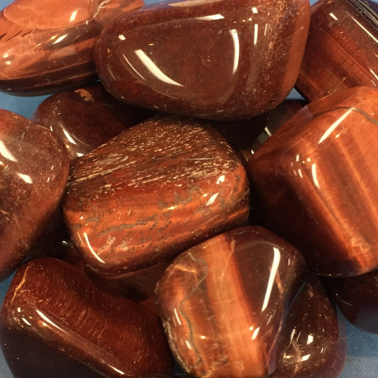 Polished red jasper stones from the Tiger’s Eye Tumbled collection with smooth surfaces