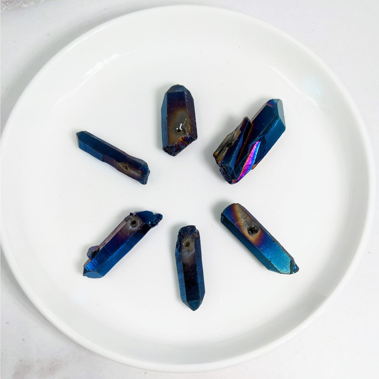 White plate with five blue crystals from the Titanium Aura Quartz Point Bead #LV3605 pack