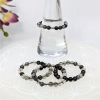 Thumbnail for Black and clear beaded bracelets displayed on a tourmalinated quartz stretch ring