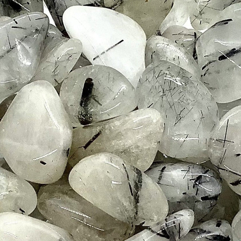 Tumbled Tourmalinated Quartz crystals showcasing black needle-like inclusions