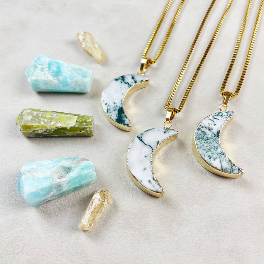 Three gold Tree Agate crescent moon necklaces with marbled inlay